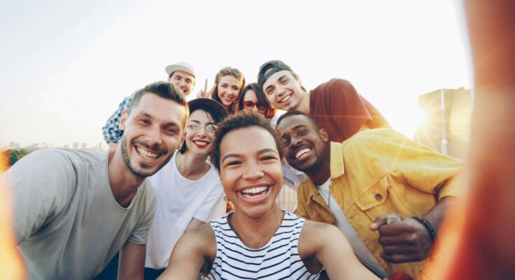 Group of diverse people smiling outdoors – representing positive community.